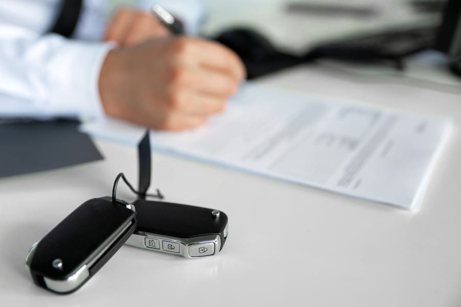 Autoschlüssel auf Tisch mit Papieren zum Ummelden